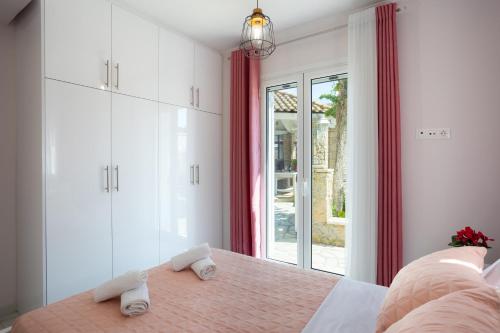 1 dormitorio con cama y ventana grande en Nina's Luxury Apartments, en Corfú