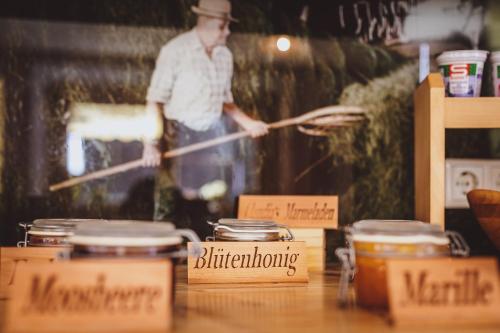 a man standing in a kitchen holding a utensil at Panorama Hotel Guggenbichl - inkl Sommerkarte, einmaliger Eintritt ins Tauern Spa & bester Ausblick über Kaprun in Kaprun