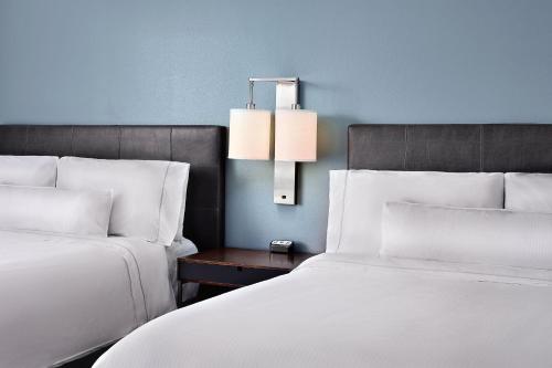 漢諾瓦的住宿－BWI機場阿倫德爾米爾斯埃利門特酒店，一间卧室配有两张床和一张带台灯的桌子