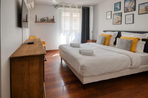- une chambre avec un grand lit blanc et une table en bois dans l'établissement LE CARNOT Apartment for 2 By Sunset, à Antibes