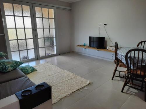 a living room with a couch and a table at Carpe diem Beach House - Jardim Peró - Cabo Frio RJ in Cabo Frio