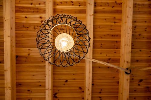 a ceiling light hanging from a wooden wall at George's Paradise in Afantou
