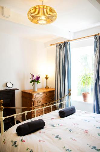 a bedroom with a bed with two pillows on it at Lovely cottage with private garden in Penryn