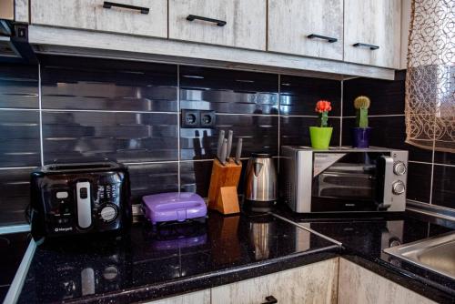 a kitchen with a black counter top with a microwave at George's Paradise in Afantou