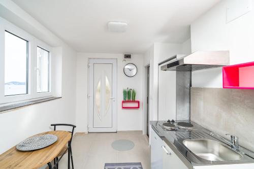 a kitchen with a sink and a table in it at Villa Green Sunset in Dubrovnik