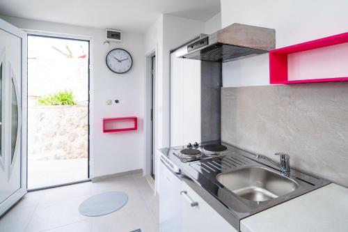 a kitchen with a sink and a clock on the wall at Villa Green Sunset in Dubrovnik