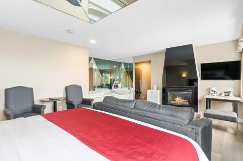 a bedroom with a large bed and a fireplace at Hotel Bromont in Bromont