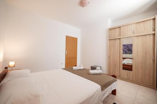 a bedroom with a large bed and a wooden cabinet at Villa Stone House with Pool in Nin
