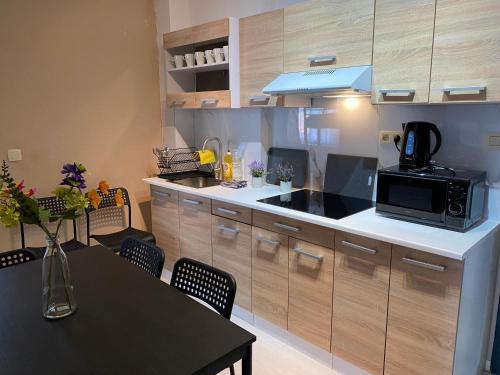 a kitchen with a microwave and a table with chairs at Apartments Bex. in Antwerp
