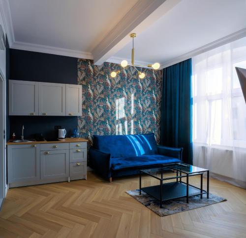 een woonkamer met een blauwe bank en een tafel bij Apartament Zwycięzców 2 in Stargard