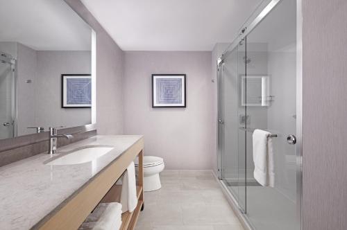 a bathroom with a toilet and a sink and a shower at Hyatt Place Melbourne Airport, Fl in Melbourne