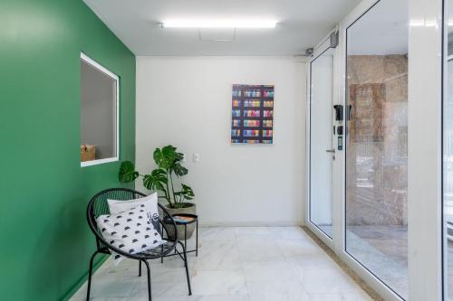 un corridoio con sedia e pareti verdi di Duque 1705 by LikeHome a Porto Alegre