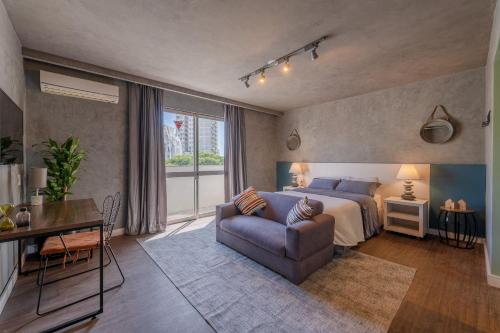 una camera da letto con un letto, un divano e un tavolo di Duque 1705 by LikeHome a Porto Alegre