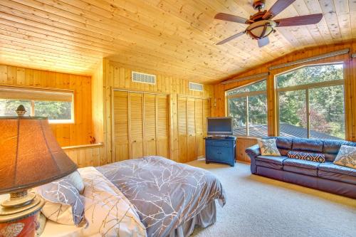 RonaldにあるRonald Vacation Rental Cabin with Private Hot Tub!のベッドルーム1室(ベッド1台、ソファ、天井ファン付)