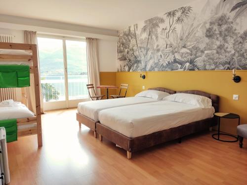a bedroom with a bed and a painting on the wall at Garden Hotel Primavera in Brissago