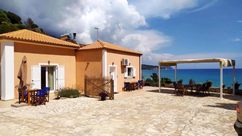 a house with a patio with a table and chairs at NIKOS & SPIROS in Trapezaki