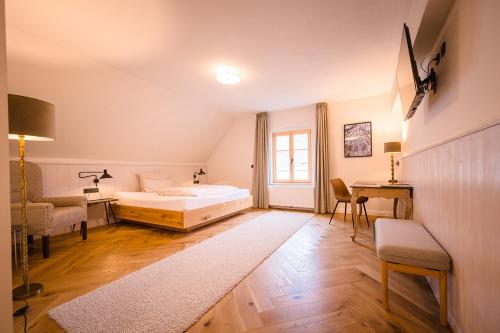 a bedroom with a bed and a desk and a chair at Brauereigasthof-Jakob in Nittenau