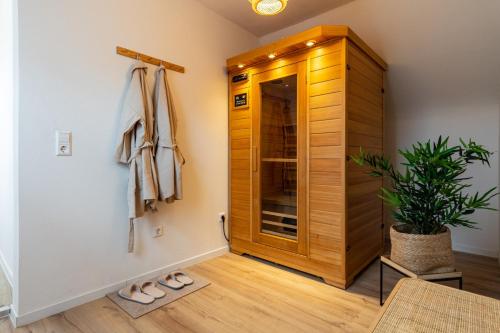 La salle de bains est pourvue d'une douche à l'italienne et d'une armoire en bois. dans l'établissement RELAX-Apartment, Sauna, Free Coffee, 105m2, à Mühlacker