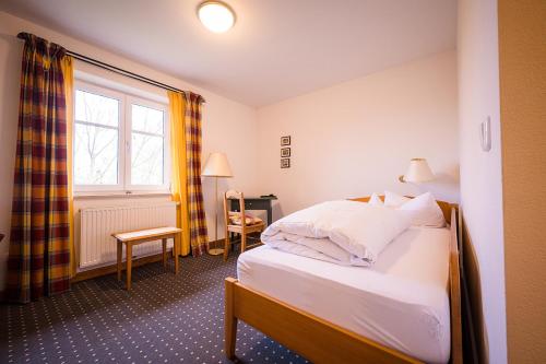 a hotel room with a bed and a window at Brauereigasthof-Jakob in Nittenau