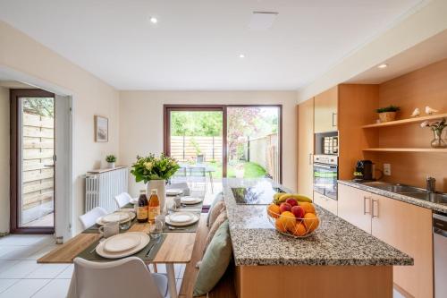 une cuisine avec une table avec un bol de fruits dessus dans l'établissement Idéal Famille: Jardin, Proche Commerces & Plage, à Bray-Dunes