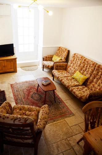a living room with couches and a coffee table at Lovely cottage with private garden in Penryn