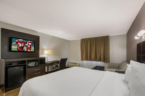 a hotel room with a bed and a flat screen tv at Red Roof Inn PLUS+ & Suites Knoxville West - Cedar Bluff in Knoxville