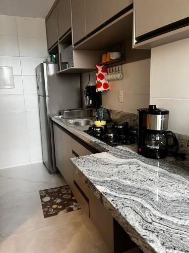 uma cozinha com uma bancada e um frigorífico em Temporada 203 em Vitória