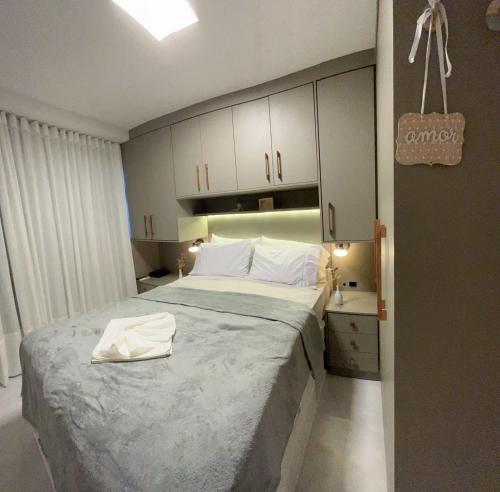 a bedroom with a large bed and white cabinets at Temporada 203 in Vitória