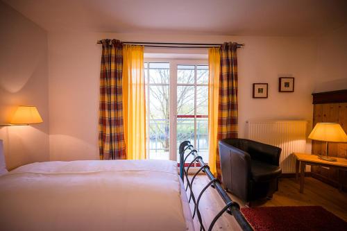 a bedroom with a bed and a window at Brauereigasthof-Jakob in Nittenau