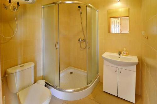 W łazience znajduje się prysznic, toaleta i umywalka. w obiekcie Domki Biały Łabędź w mieście Jarosławiec