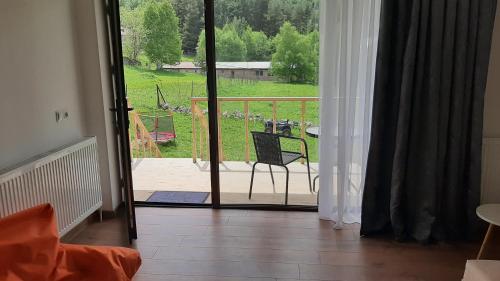 a room with a door open to a patio with a chair at Terkhena in Stepantsminda