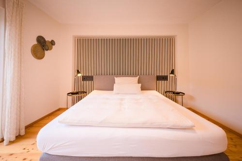 a bedroom with a large white bed in a room at Brauereigasthof-Jakob in Nittenau