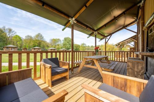 a wooden deck with a table and chairs on it at Sunny Trio in Zeewolde