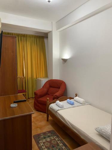 1 dormitorio con 1 cama y 1 silla roja en ~Villa Gloria~ en Durrës