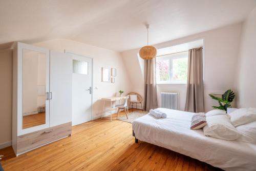 a bedroom with a large white bed and a mirror at Idéal Famille: Jardin, Proche Commerces & Plage in Bray-Dunes