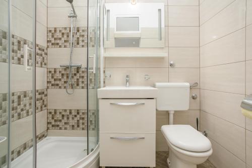 een badkamer met een toilet, een wastafel en een douche bij Apartment Gloria in Opatija