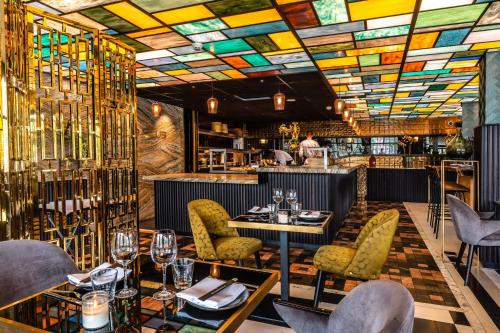 a restaurant with stained glass ceilings and tables and chairs at Apollo Hotel Amsterdam, a Tribute Portfolio Hotel in Amsterdam