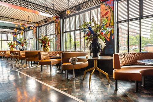 a restaurant with chairs and a table with a vase of flowers at Apollo Hotel Amsterdam, a Tribute Portfolio Hotel in Amsterdam