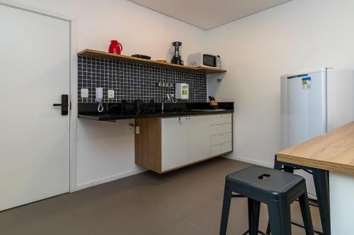 Il comprend une petite cuisine avec un comptoir et un réfrigérateur. dans l'établissement Alice Thomé, à São Paulo