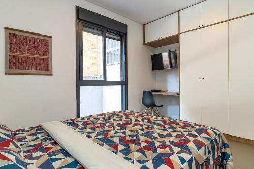 - une chambre avec un lit doté d'une couette colorée dans l'établissement Alice Thomé, à São Paulo