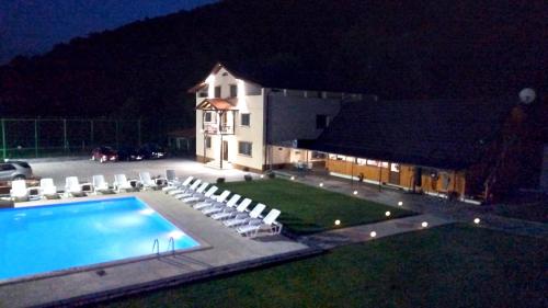 a house with a swimming pool and chairs at night at Casa Munty in Orlat