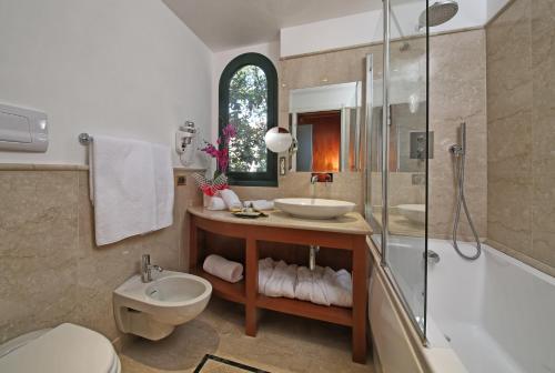 a bathroom with a sink and a shower and a toilet at Hotel Villa Capri in Gardone Riviera