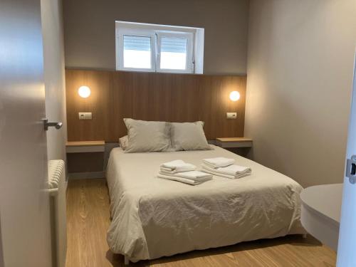 een slaapkamer met een bed met twee handdoeken erop bij Céntrico con jardín en Santander in Santander