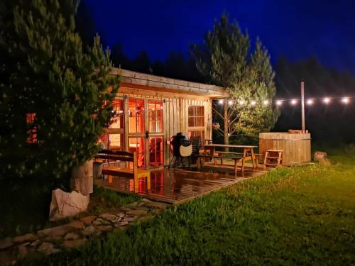a cabin at night with a person standing in front of it at Männisalu cozy houses with hot tube and many extras 