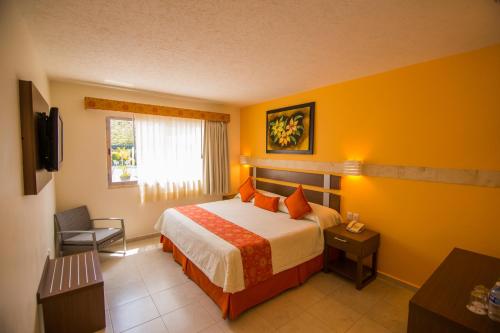 a hotel room with a bed and a window at Hotel Tulija Palenque in Palenque
