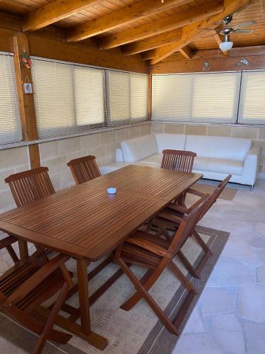 a wooden table and chairs in a room with a couch at A due passi dal Mare in Torre rinalda