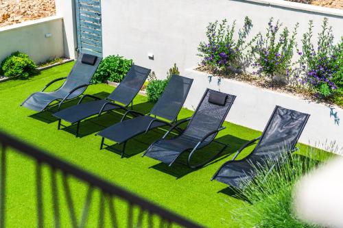 a group of lawn chairs sitting on the grass at Apartment Ivana in Šibenik