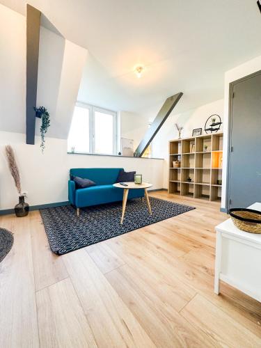 Una sala de estar con un sofá azul y una mesa. en NEW: Le Lumineux face à la gare !, en Guingamp