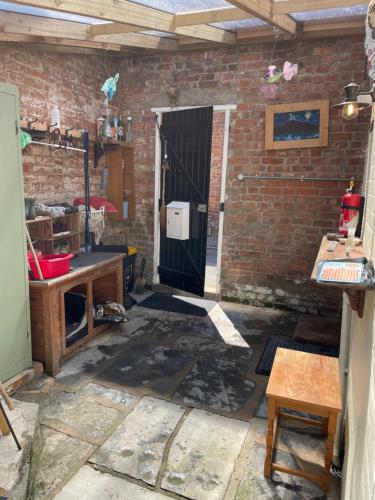 Zimmer mit Tür und Ziegelwand in der Unterkunft Morning Sun Apartment Glastonbury in Glastonbury