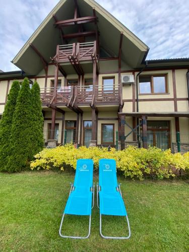 two blue chairs in front of a house at Bešeňová Apartmán Relax in Bešeňová